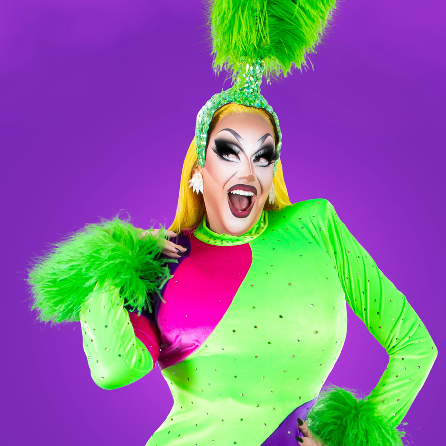 Photo of Kita Mean wearing a bright lime green outfit, on a purple background